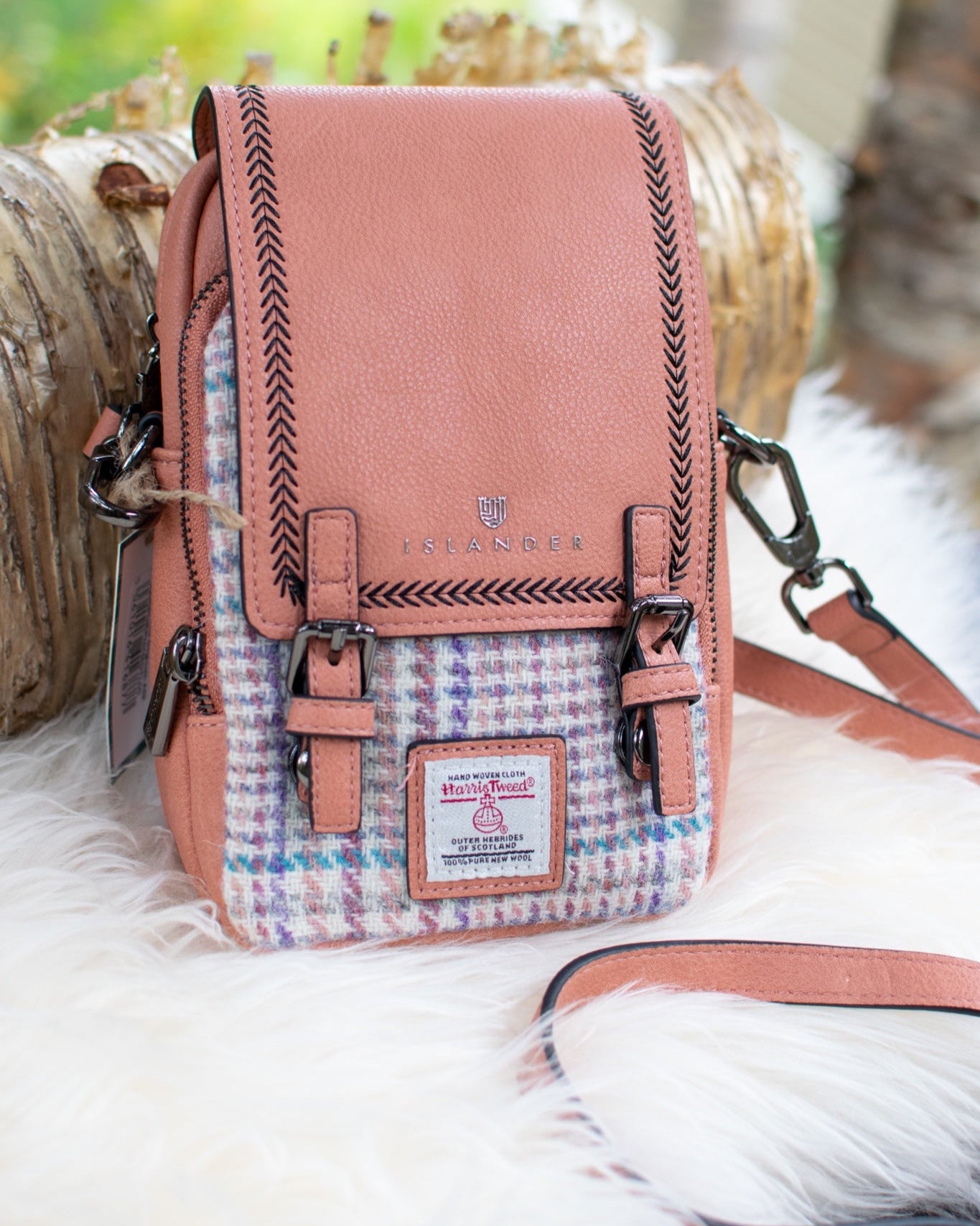 Pink crossbody bag with plaid pattern on a white surface