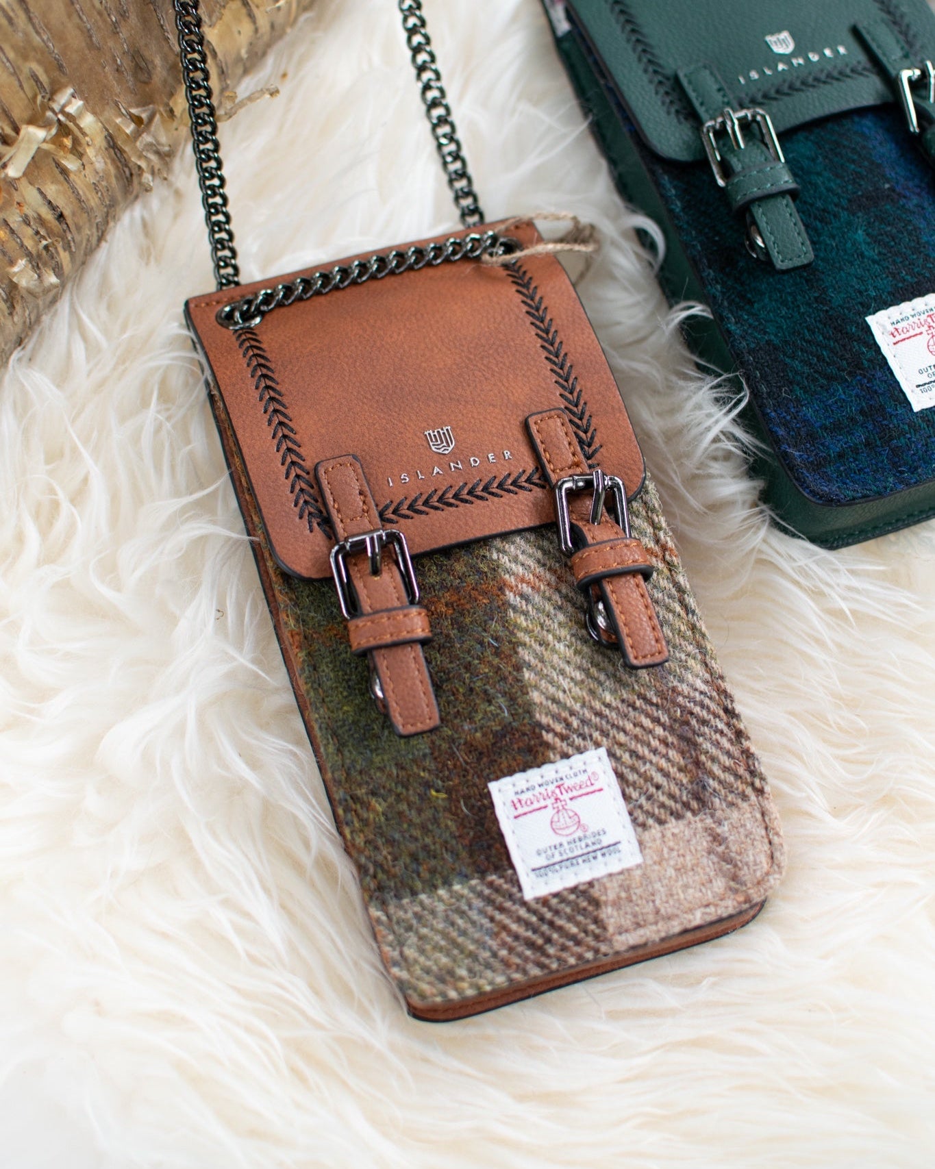 Two leather bags, one brown and one green, on a textured white surface.