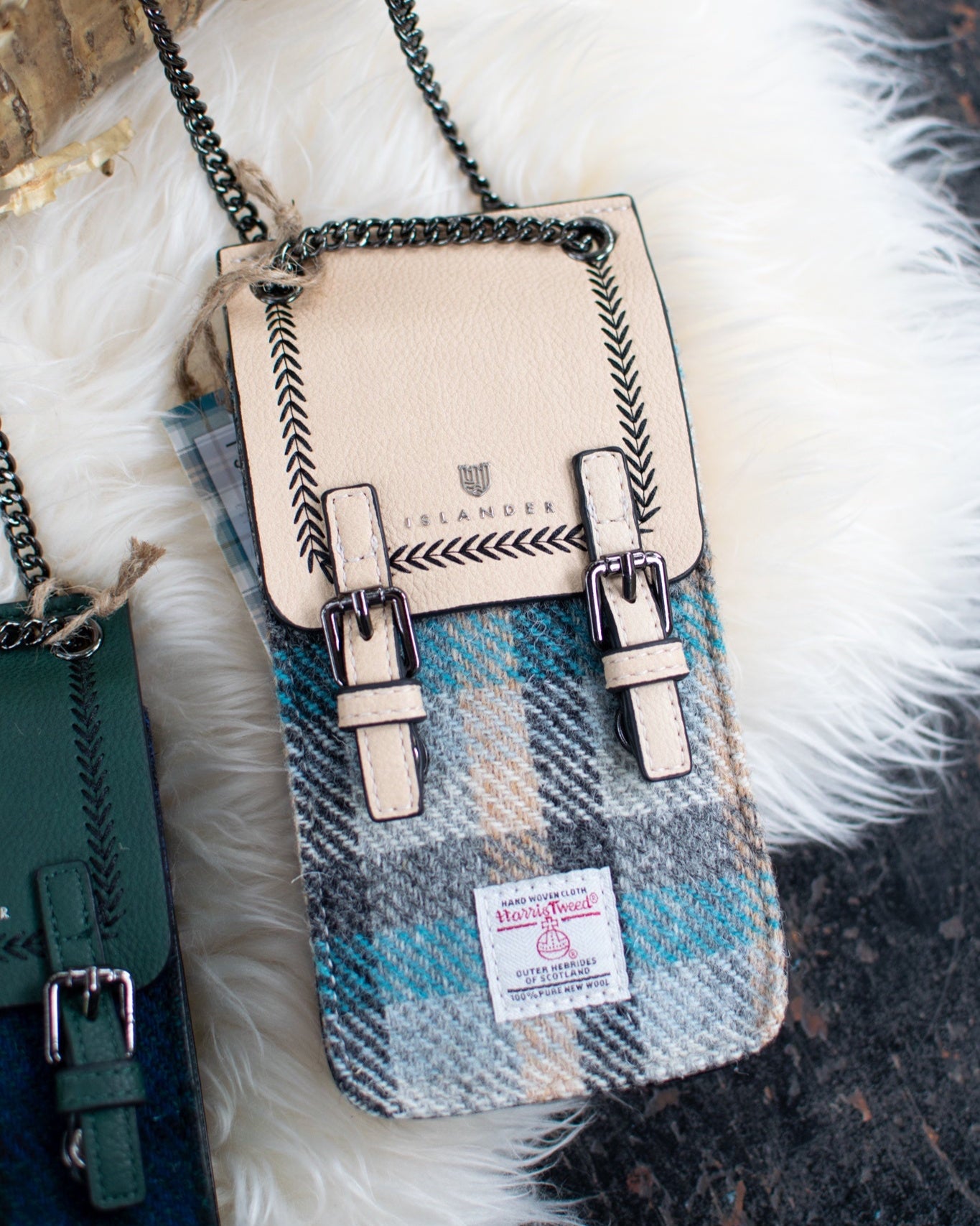 Handbag with plaid pattern held by a person wearing a white outfit.