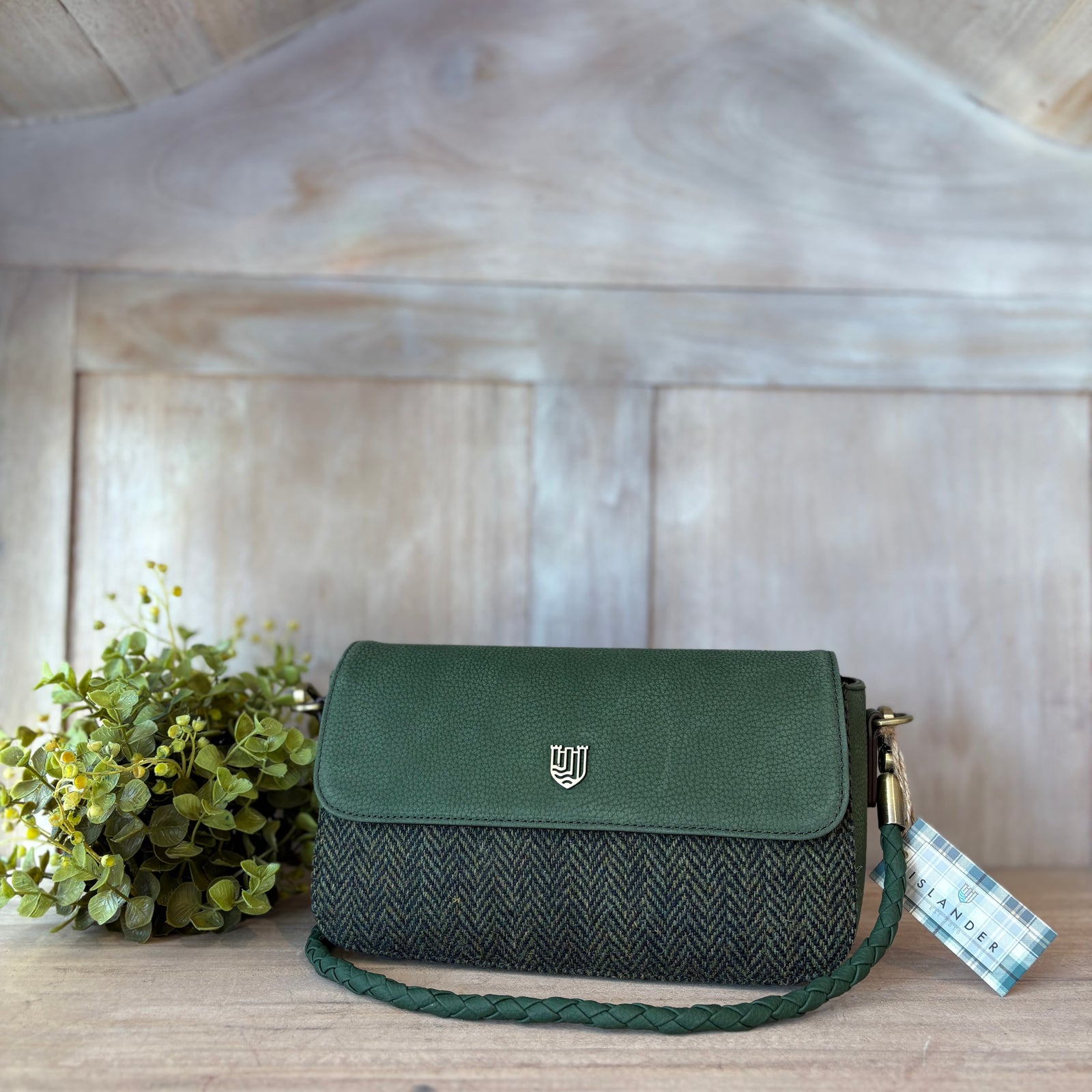 Green crossbody bag on a tree branch with a blurred natural background