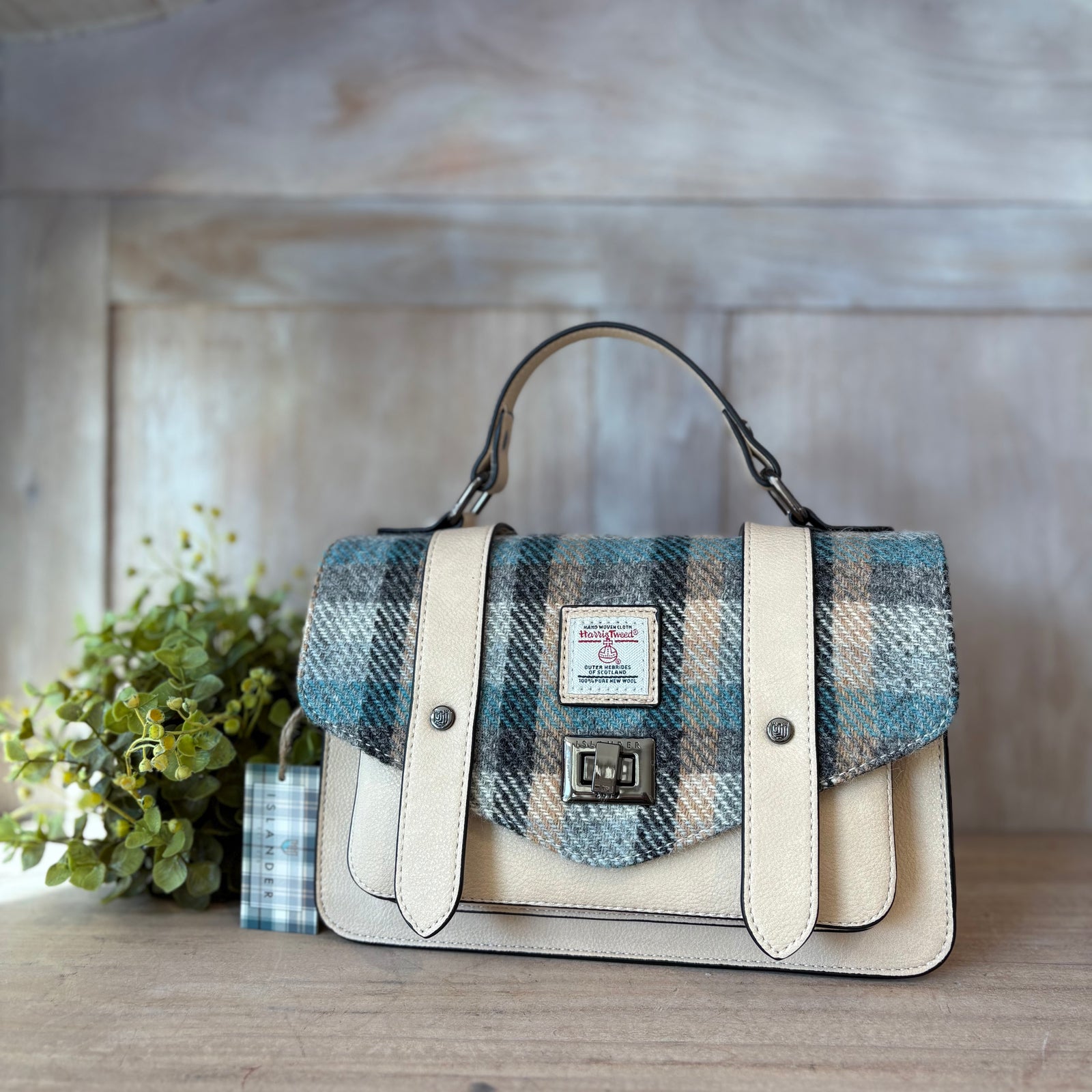 Handbag with plaid pattern on a wooden table outdoors