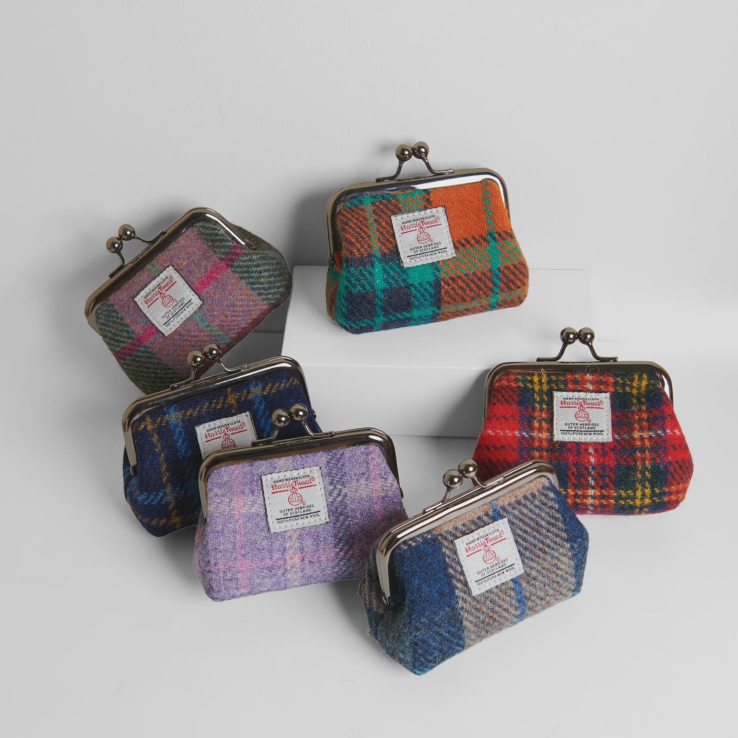 Three plaid coin purses on a rock with a natural background