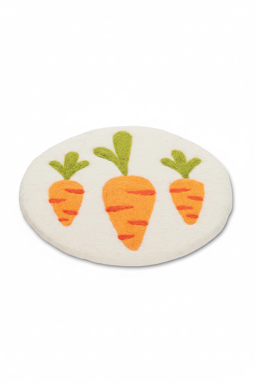 Round white trivet with orange carrots and green tops on a white background